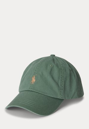 Casquette de baseball verte avec une visière incurvée et un petit logo de joueur de polo beige brodé sur le panneau avant, sur fond blanc.