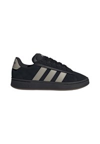Schwarzer Adidas-Sneaker mit grauen drei Streifen, schwarzen Schnürsenkeln und einer schwarzen Sohle, von der Seite auf einem weißen Hintergrund gezeigt.