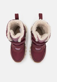 Botas impermeables burdeos con un suave forro crema, correas de velcro y suelas resistentes en color beige, presentando un diseño cosido y una pestaña para tirar.