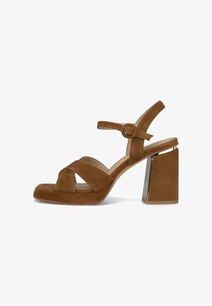 Bruine suède dames sandaal met open tenen, gekruiste banden, verstelbare enkelriem met gesp en hoge blokhak met metalen accenten.