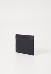 Svart lærkortholder med teksturert overflate, med fire kortlommer og slank profil. Minimalistisk design, ingen synlig maskinvare.