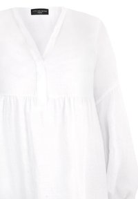 Biała lniana bluzka z dekoltem w serek, długimi rękawami i marszczonym paskiem w talii. Charakteryzuje się prostą, gładką fakturą i minimalistycznym designem.