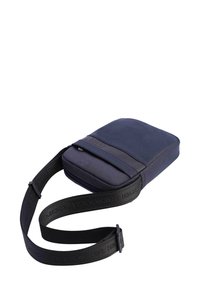 Bolso cruzado compacto de color azul marino con correa ajustable negra y bolsillo frontal con cremallera, diseñado para un uso casual diario.