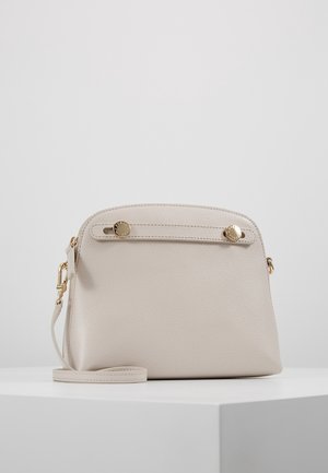 Sac bandoulière en cuir beige texturé avec des accessoires dorés, une bandoulière amovible et deux boutons dorés sur le devant.
