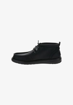 Bottines en cuir noir avec une finition lisse, un design à lacets et une semelle rembourrée. Présente un bout arrondi et une tirette à l'arrière.