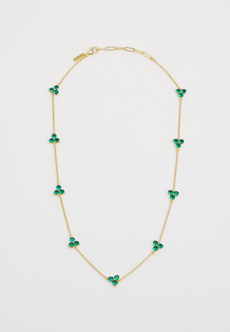 Gold chain necklace featuring multiple green gem accents, arranged in a clover pattern, with a clasp closure and delicate links.