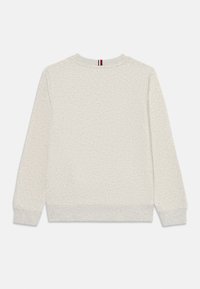 Sweatshirt gris clair avec un tissu texturé, des poignets et un ourlet côtelés, et une petite bande de logo au niveau du cou au dos. Design simple avec col rond.