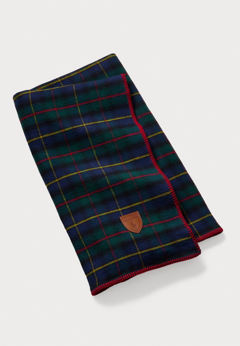 Tamsiai žalios, mėlynos ir raudonos spalvų plaid šalikas. Yra odinė logotipo etikete ir kontrastinga raudona siuvinėjimo aplink kraštus. Minkšta tekstūra.