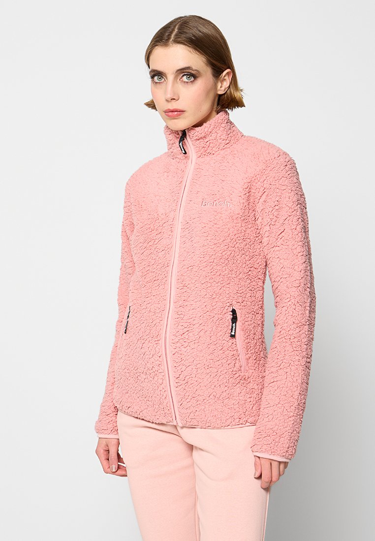 Polarowa kurtka w delikatnym różu z wysokim kołnierzem, pełnym zamkiem błyskawicznym z przodu i dwoma bocznymi kieszeniami. Teksturowany materiał z logo "Banah" na klatce piersiowej.
