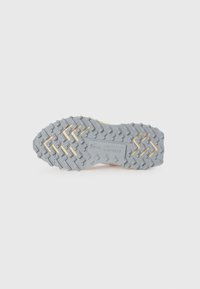Suela de zapato Lacoste en un material de goma gris con un patrón texturizado y acentos amarillos, diseñada para ofrecer tracción y estabilidad.