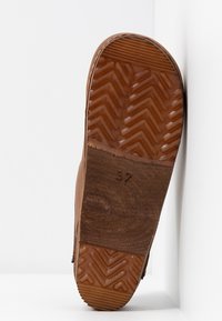 Brown shoe sole with a textured rubber tread featuring a herringbone pattern. The size "37" is embossed on the flat, smooth section.