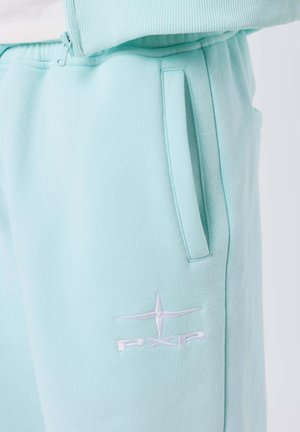Pantaloni della tuta blu chiaro con tasca laterale e logo star ricamato bianco con "PXP" sulla coscia.