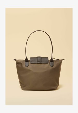 Pruun kandekott pikkade tumedate sangade ja klapidetailiga, taustaks lihtne beež varjund.