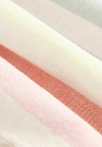 Weiche Stofffalten mit horizontalen Streifen in Weiß-, Creme-, Pink- und Koralltönen mit sichtbarer gewebter Textur.
