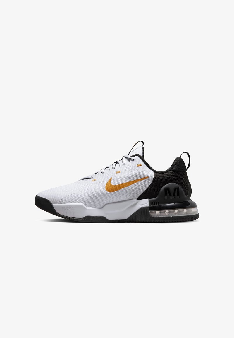 Zapatilla deportiva blanca con talón negro, con parte superior de malla, un swoosh dorado de Nike y amortiguación translúcida en la suela.