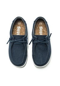 Scarpe in tela blu navy con superficie testurizzata, dotate di lacci elastici e insole in sughero, su uno sfondo bianco.