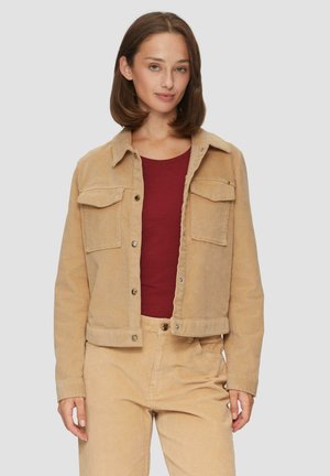 Kastanjebruine corduroy jacket met twee borstzakken, drukknoopjes en een cropped ontwerp. Gekocht over een burgundy shirt en gecombineerd met bijpassende broek.