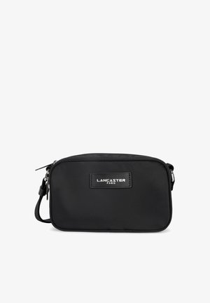 Sac bandoulière en nylon noir de forme rectangulaire, fermeture éclair, ferrures argentées et patch en cuir de marque. Sangle réglable incluse.