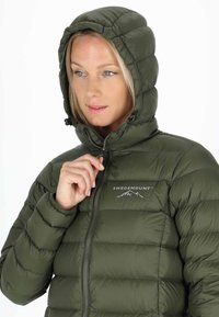 Mörkgrön pufferjacka med huva, försedd med dragkedjestängning, horisontellt quiltat mönster, logotyp på bröstet och dragsnöre vid huvan.