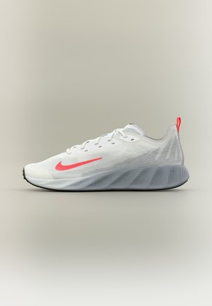 Hvid atletiksneaker med rød Nike swoosh, åndbart mesh-overdel, hævet grå sål og rød hælflig på neutral baggrund.