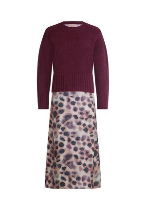 Bordeaux striktrøje med ribbet kant, parret med en lang, flodlignende nederdel med et pastelfarvet leopardmønster i nuancer af lilla og sort.