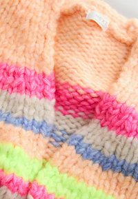 Pull en tricot coloré avec des rayures en rose, pêche, gris, bleu et vert fluo, doté d'une finition texturée et duveteuse. Étiquette visible au niveau de l'encolure.