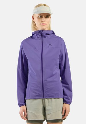 Lightweight purple jacket with a hood, zip closure, elastic cuffs, and a logo accent. Worn with light gray shorts, showcasing a sporty design.