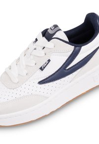 Sneaker bianco con accenti blu navy, realizzato in pelle e suede. Presenta dettagli perforati, una suola in gomma testurizzata e punta arrotondata.