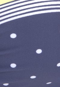 Tissu bleu marine avec des pois blancs et un design à rayures jaunes. Texture douce, surface lisse et motifs circulaires régulièrement espacés.