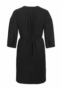 Czarna sukienka z miękkiego materiału, z rękawami do połowy przedramienia, plisowanym tyłem oraz taliowanym krojem z dopasowanym paskiem.