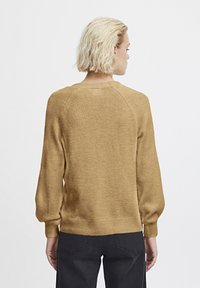 Senfgelbes Sweatshirt aus strukturiertem, gestricktem Material mit Rundhalsausschnitt und gepufften, gerippten langen Ärmeln.