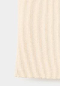 Gros plan d’un tissu tricoté côtelé de couleur crème avec des lignes texturées verticales et une apparence douce et confortable.
