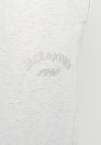 Světle šedá bezramínková bavlněná košile s jemnou texturou a vyšívaným logem "JACK & JONES 1990" ve shodné barvě nitě.