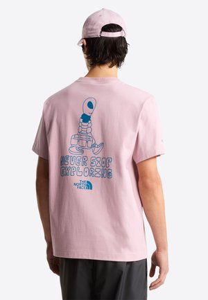 Pink cotton t-shirt featuring a blue graphic of a character with a backpack, text "NEVER STOP EXPLORING," and logo on the back.