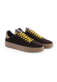 Brown suede sneakers with yellow laces, rubber sole, and gold accents at the heel. Smooth texture and classic low-top design.