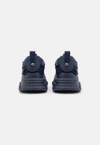 Zapatillas de deporte azul marino con paneles de malla, collar acolchado en el talón y tirador. Punta redondeada y suela gruesa con detalle texturizado.