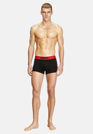 Boxers noirs avec une ceinture élastique rouge arborant le logo Diesel, fabriqués à partir d'un matériau lisse, design ajusté pour le confort.