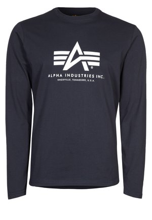 Mornarica košulja dugih rukava s bijelim logotipom Alpha Industries i natpisom "ALPHA INDUSTRIES INC. KNOXVILLE, TENNESSEE, SAD." na prsima.