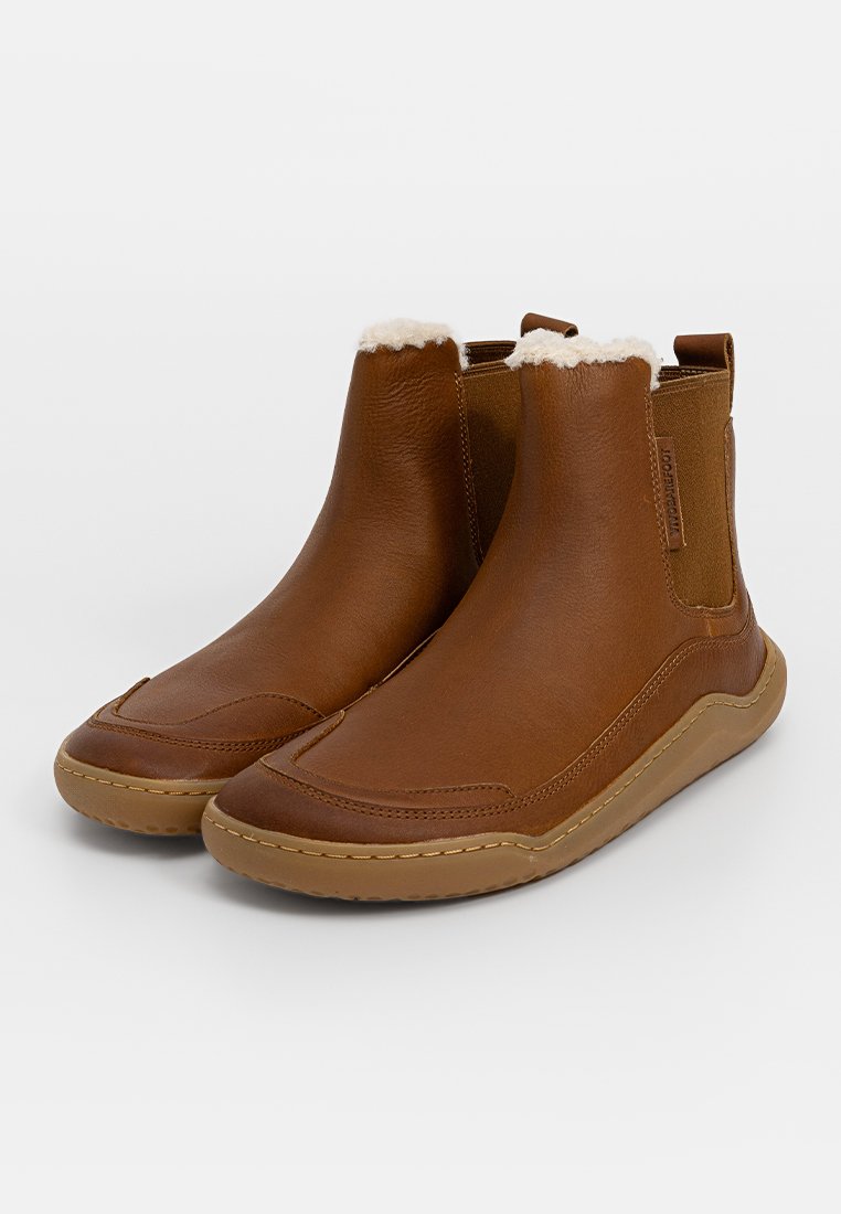 Braune Leder-Ankle-Boots mit einem weichen Fellfutter, elastischen Seitenpanelen und einer Gummisohle mit einem tanfarbenen Außensohle und gestickten Akzenten.