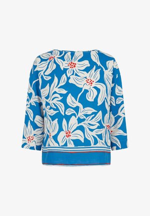 Blue long-sleeve blouse with white floral print and red flower centers, featuring a striped hem in white, red, and blue.