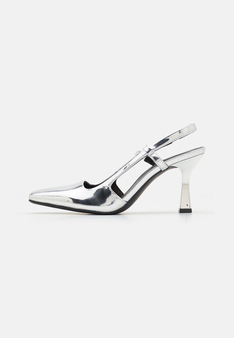 Chaussure argentée brillante à talon haut avec bride slingback, bout pointu et fine lanière sur fond blanc uni.