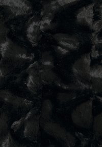 Czarna sztuczna tkanina futerkowa o miękkiej, puszystej fakturze. Charakteryzuje się falistym wzorem z różnym połyskiem i głębią, odbijającym światło w niektórych miejscach.