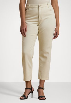 Beige high-waisted jeans met een rechte snit, voorzien van zijzakken, riemlussen en subtiele stiksels. Gepaard met zwarte sandaaltjes met bandjes.