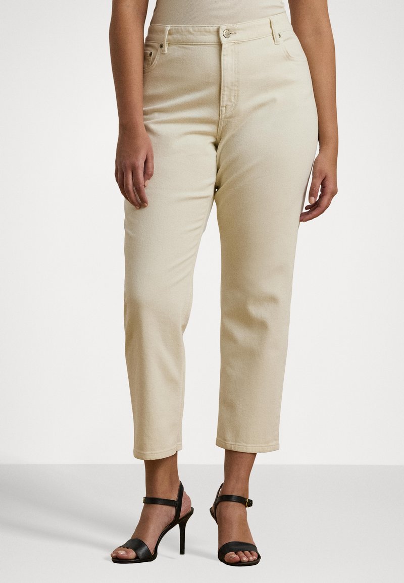 Beige høyt liv jeans med rette ben, med frontlommer, beltehemper og subtil søm. Kombinert med svarte stroppesandaler.