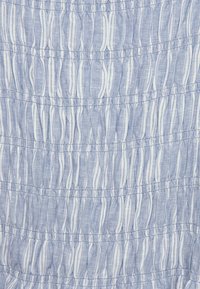 Ljusblått tyg med vertikala ränder och samlad textur. Slätt bomullsmaterial med en något genomskinlig kvalitet.