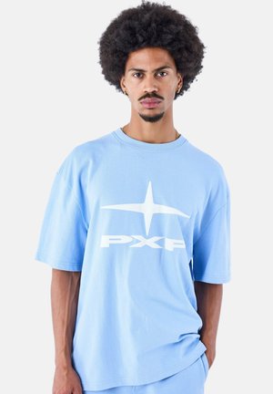 T-shirt oversize azzurro realizzato in cotone. Presenta un grande logo bianco "PXP" sul davanti. Maniche corte e vestibilità rilassata.