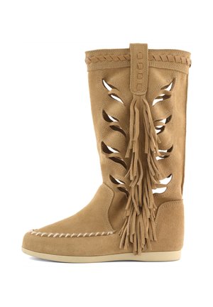 Tan suede mid-calf boot with laser-cut leaf patterns, braided trim, large side tassels, moccasin toe stitching, and flat sole.
