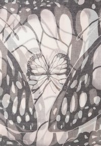 Deux ailes de papillon en noir et blanc superposées avec des motifs complexes et un petit papillon au centre.