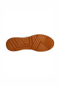 Semelle d'une chaussure avec une semelle extérieure en caoutchouc marron présentant un motif en zigzag, des lignes texturées et des rainures pour une meilleure adhérence.