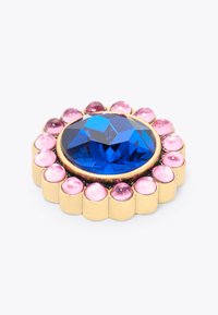 Broche ronde avec une grande pierre facettée bleue entourée de plus petites pierres roses, le tout monté sur une base en métal doré.